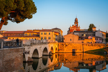 Famous Roman Bridge of Tiberius or Ponte di Tiberio in  historic center of Rimini, Italy at sunset
