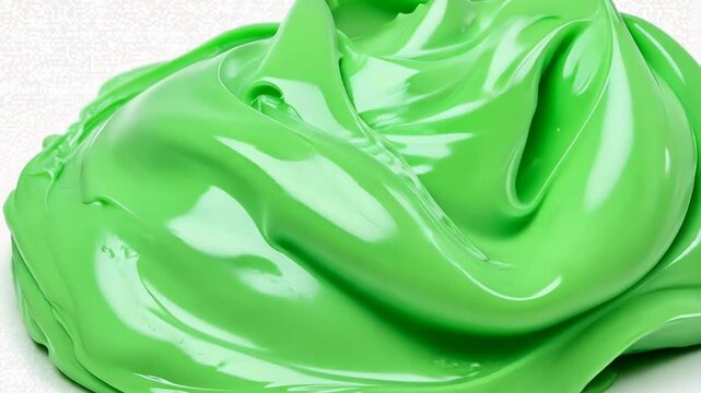 Bright green slime spreads across a surface, showcasing its glossy texture and playful color, inviting creative activities and fun