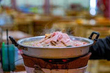 Delicious hot pot dish with fresh ingredients bubbling in boiling broth at a vibrant restaurant setting