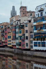 Naklejka premium Iconic Colorful Cases de l'Onyar Houses Along the Onyar River in Girona, Spain, with Basilica of Sant Feliu Tower