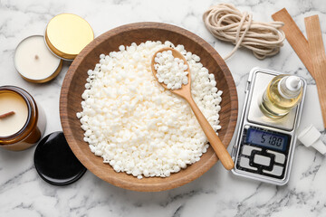 Soy wax and other supplies for making candles on white marble table, flat lay