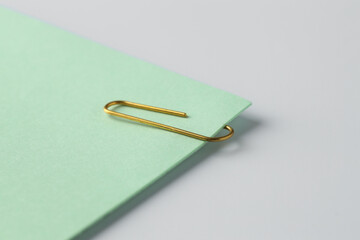 Paper note with clip on light background, closeup