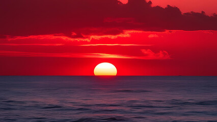 A fiery sunset descending over the expanse of the sea