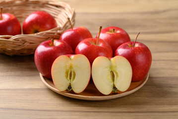 Red apple fruit (Gala apple) on wooden plate with wooden background