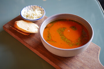 Delicious bowl of tomato soup served with bread and cheese