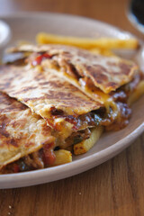 Delicious quesadilla served with golden fries in a cozy cafe