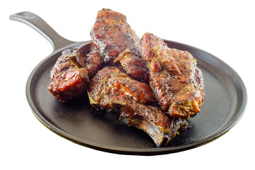 Isolated on white background smoked country style pork ribs served on a seasoned cast iron skillet. 