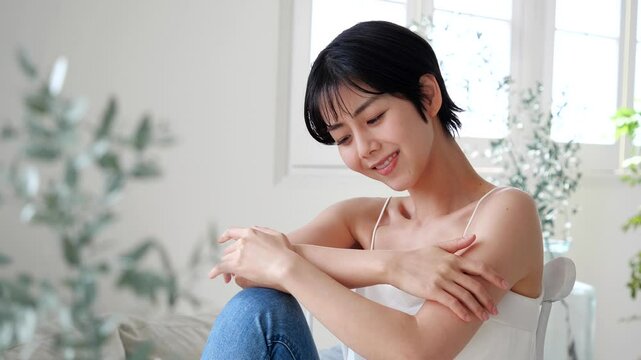 椅子に座るキャミソールの若い女性
