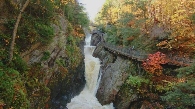 Witness the gorgeous fall foliage and flowing water of High Falls Gorge in the Adirondacks with this 4K footage. The rich autumn colors surround the tranquil creek in this scenic location.