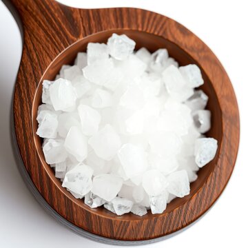 an image of a wooden spoon filled with white sugar, there is a wooden spoon filled with white sugar on a white surface