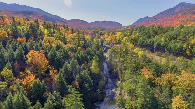 This 4K overhead drone footage showcases the winding creek in Flume Falls, flanked by a colorful autumn forest, capturing the beauty of the Adirondacks during fall.