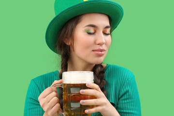 Young woman with beer on green background. St. Patrick's Day