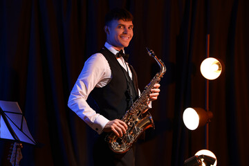 Male artist with saxophone performing on stage