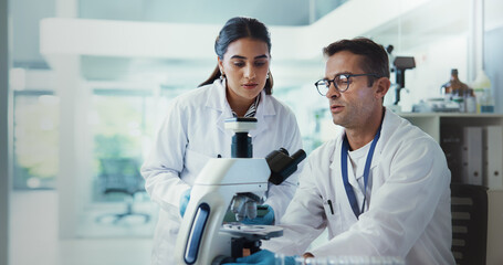 Scientist, people and microscope in lab for advice, testing and medical research. Pathology, man...