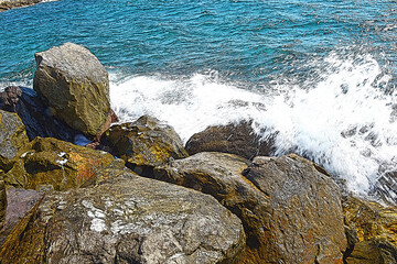 Scogli con onde e schiuma.