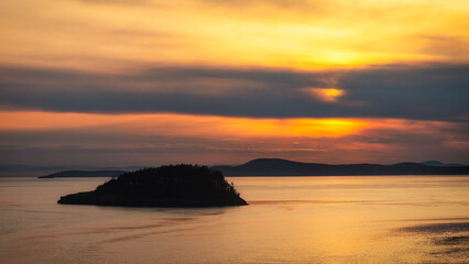 Fototapeta premium This breathtaking scene captures a sunset reflecting off the tranquil waters, with islands silhouetted against a colorful sky, evoking peace and harmony in nature.