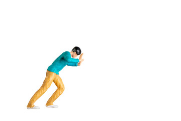Miniature Figurine Pushing Against Invisible Force isolated on white background with clipping path