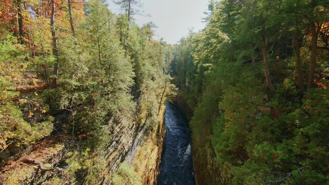 This footage captures the grandeur of Ausable Chasm, often referred to as the 'Grand Canyon of the Adirondacks,' with its stunning sandstone formations and river flowing through the gorge.