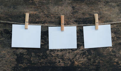 Rows of white sticky notes hung with string and wooden clips. copy space for text