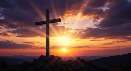 Wooden cross on a hill at sunset