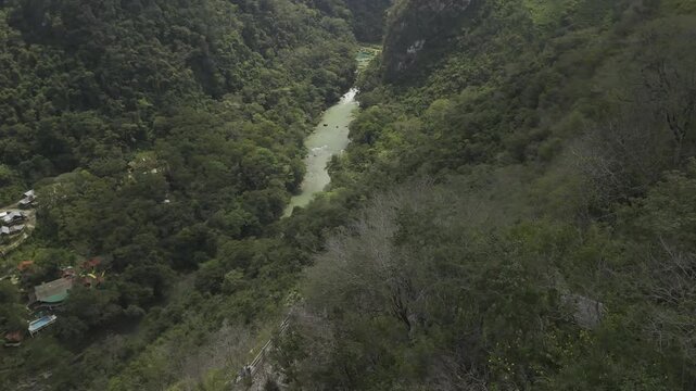 Drone orbits to left overlooking Semuc Champey National Park and looks back on viewpoint across the Cahabon River in Guatemala
