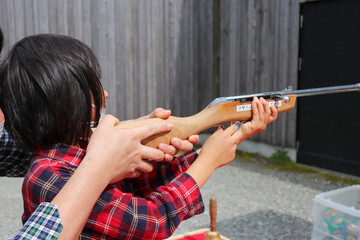 祭りの縁日の射的を楽しむ親子