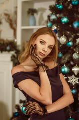 Fototapeta premium beautiful young blonde in evening dress posing against the background of a Christmas tree