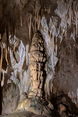 An impressive stalactite formation emerges from the cave ceiling, showcasing nature's artistry and the geological processes over time, inspiring awe for Earth's ancient beauty.