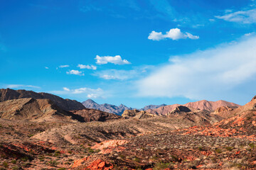 Beautiful morning landscape in the South Western United States desert near Utah, New Mexico, Nevada and Arizona with hills and mountains in the distance under a blue sky with light clouds