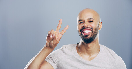 Studio, black man and portrait with sign for peace, support and motivation for positive feedback. Mockup space, male person and model with hand gesture for v symbol, good mood by gray background