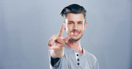Portrait, space and happy man with peace sign, confidence or positive attitude for expression. Grey...
