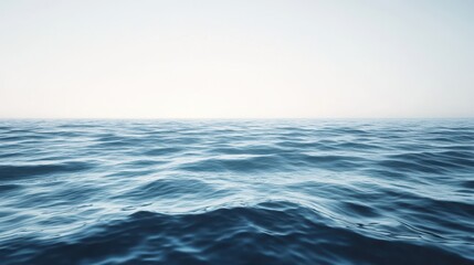 Fototapeta premium Gentle ocean waves ripple beneath a calm, clear sky, creating a serene and tranquil seascape.