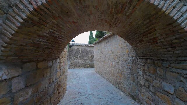 Stone arch in the picturesque narrow streets of the medieval town of Baeza, Andalusia.