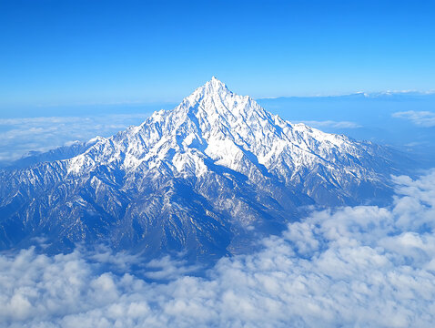 A breathtaking aerial view of a snow-capped mountain peak piercing through a sea of clouds under a clear blue sky