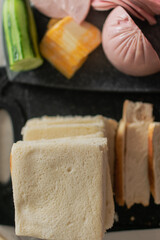 a stack of white bread on the table, ham and cheese for making sandwiches. a quick breakfast every morning