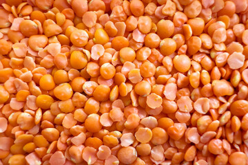 Red lentils. Close-up of dry uncooked orange lentil grains. Top view of heap of dal, raw daa or dhal, masoor, Lens esculenta background. Healthy food ingredient.