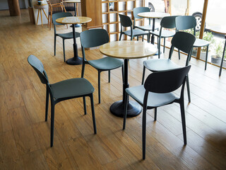 Empty restaurant chairs with no people to use them and an ashtray on table