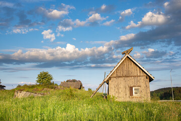 Obraz premium A small wooden house sits in a field of grass