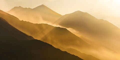 Sunrise in a misty mountain landscape, with soft light illuminating the misty valleys.