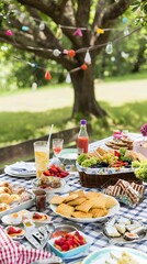 A large picnic table set for an outdoor gathering with food and drinks in a peaceful park setting.