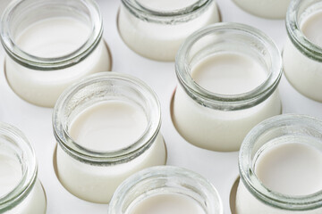 Closeup view of small jars with freshly prepared homemade yogurt