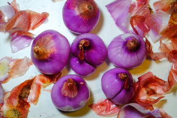 Peeled shallot and shallot skin crumbs. The shallot with purplish color and shallot skin isolated on White Backgrounds. Closeup Objects. Graphic Resources. Texture and Details. Macrophotgraphy