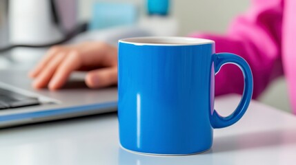 Bright Blue Mug on Desk with Laptop and Hand in Background