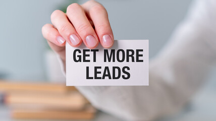 A person is holding a card that says Get more leads