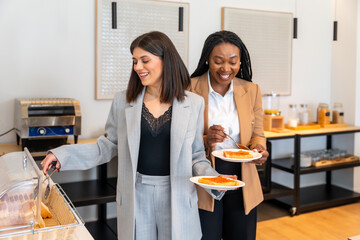 Businesswomen enjoying breakfast at hotel buffet during business trip