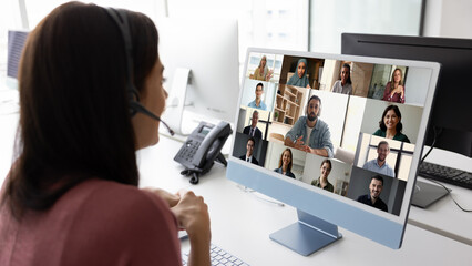 Hispanic businesswoman talking on video conference chat with diverse team of colleagues, business...