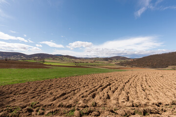 Plowed field and blue sky during spring