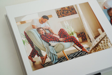 The pages of a photo book with color photos of a pregnant blonde and a man.