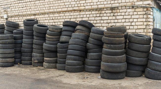 Panoramic view of storage of discarded old car tires outdoors, showcasing a pile of used tires ready for recycling. Highlighting environmental concerns and rubber waste management