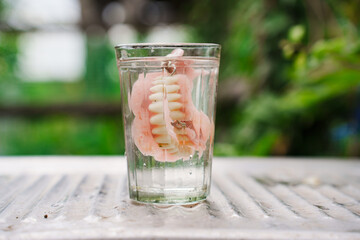 false jaw in a faceted glass of water.